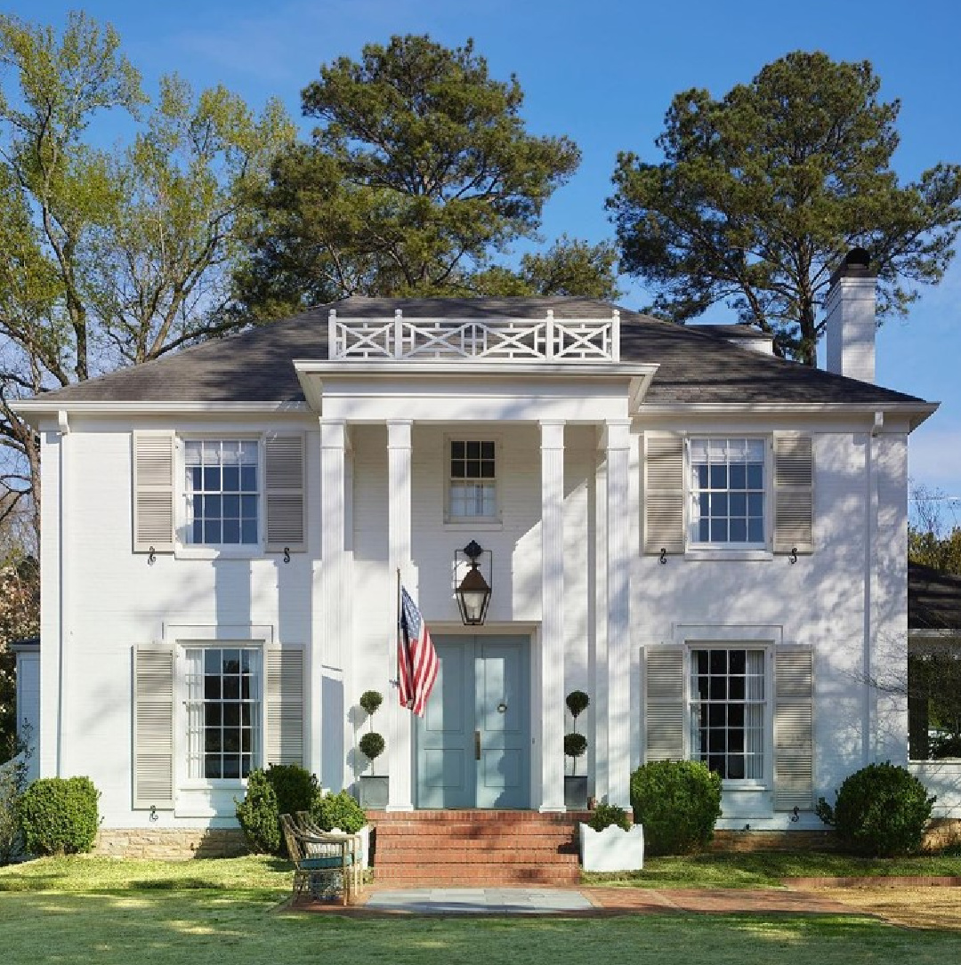 BM Simply White on siding, Elmira White on shutters of a gorgeous classic home with French blue front doors. Design: Lauren Conner; Birmingham Home & Garden. #whitehouseexteriors #bmsimplywhite