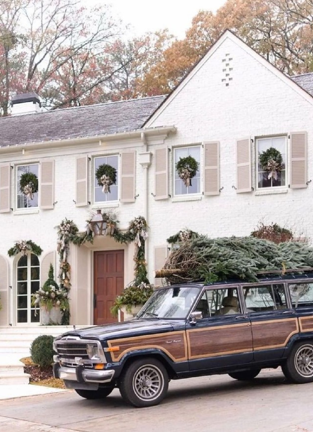 @dhcphoto - beautiful white two story home in Atlanta with tan shutters decorated with wreaths for the holidays. #outdoorholidaydecor #atlantaholidayhome