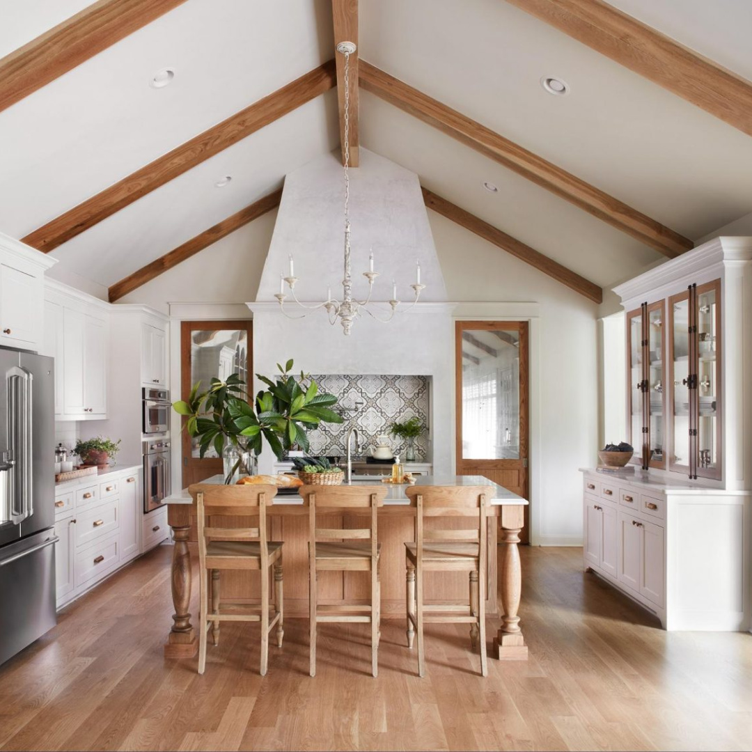 HGTV Fixer Upper "The Club House" French country kitchen with wood ceiling beams, white cabinets, and design by Joanna Gaines.