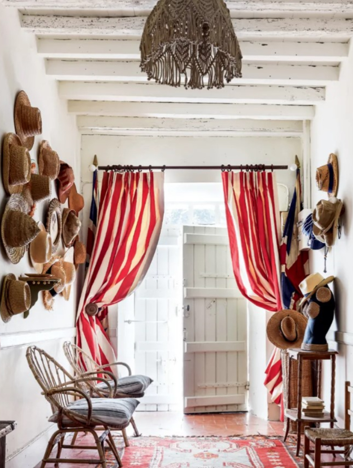 Colorful red stripe curtains and hat collection on wall of eclectic interior in a 19th century French cottage in Toulouse by Lucinda Chambers - photo by Paul Massey. #frenchcottage #frenchfarmhouse #interiordesign