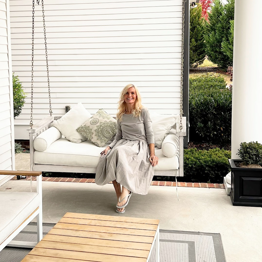 Southern front porch with swing, haint blue ceiling, and Michele of Hello Lovely.