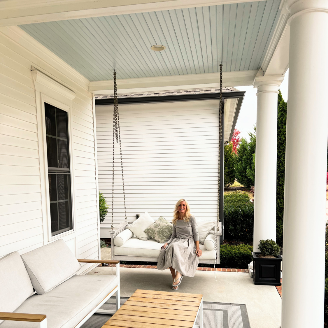 Southern front porch with swing, haint blue ceiling, and Michele of Hello Lovely.