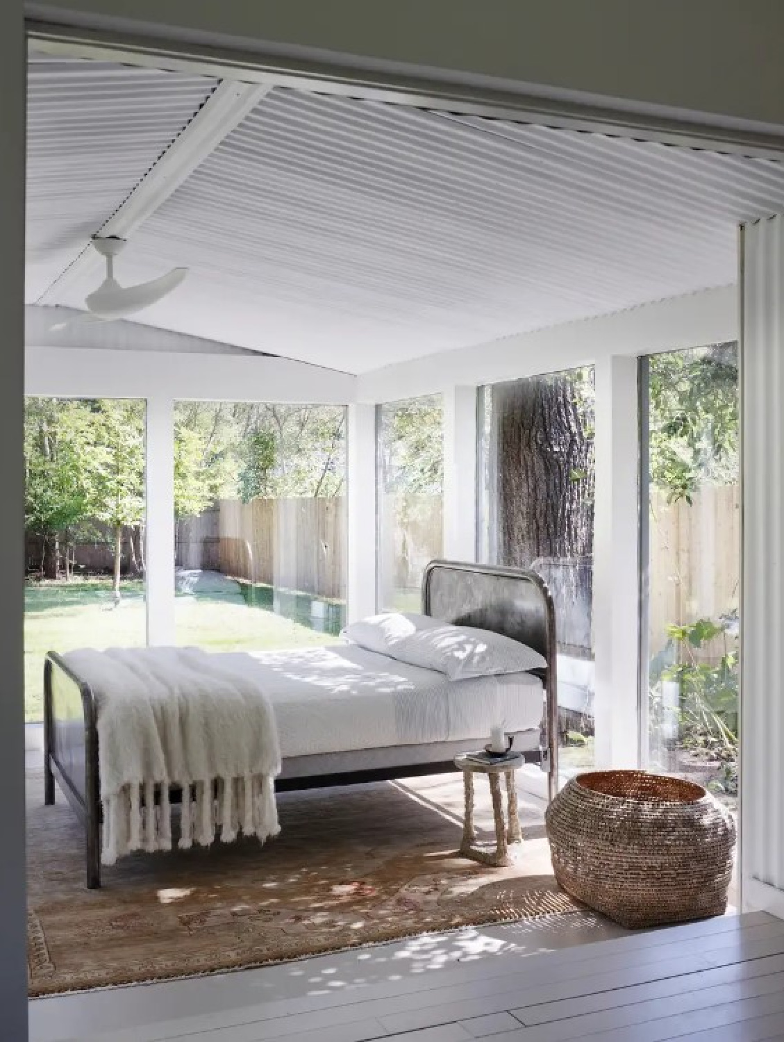 Sun room with bed and minimal decoration. Interior design by Michael Del Piero (Richard Powers - photo) for TRAVELED AND TEXTURAL (Beta-Plus, 2023). #modernrustic #michaeldelpiero