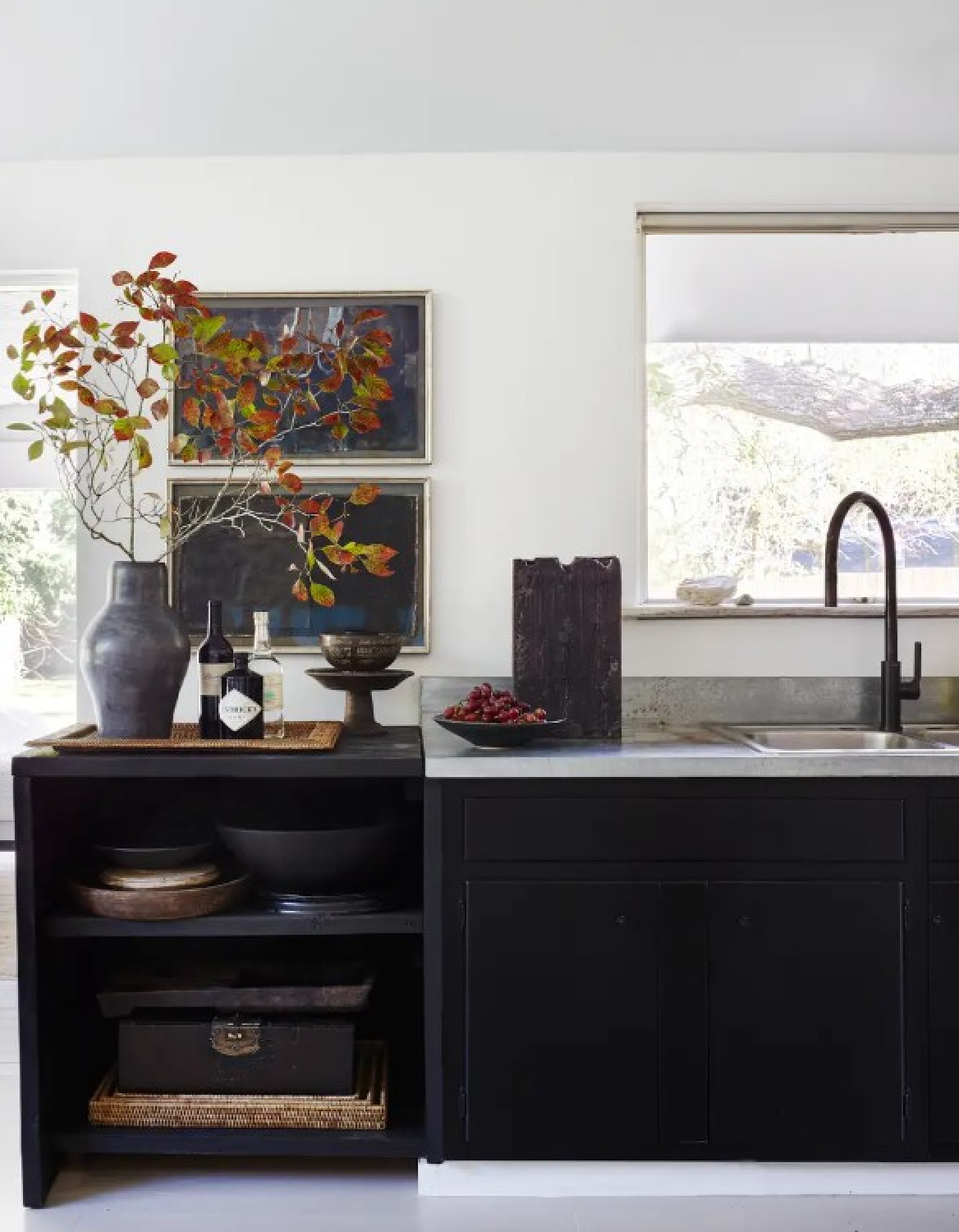 Moody dark base cabinets with crisp white walls in kitchen. Interior design by Michael Del Piero (Richard Powers - photo) for TRAVELED AND TEXTURAL (Beta-Plus, 2023). #modernrustic #michaeldelpiero