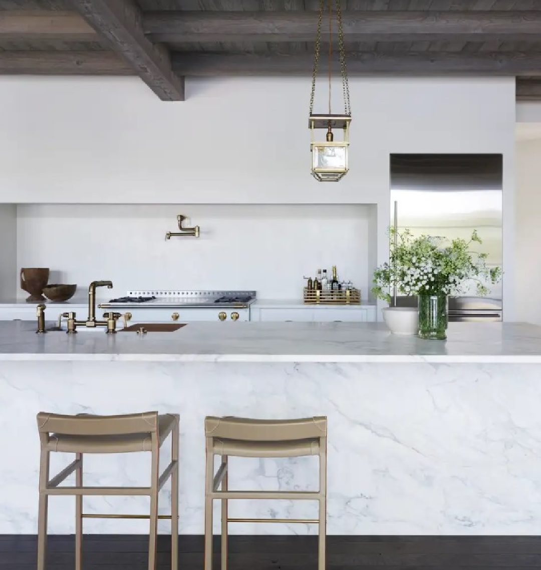 Rustic wood ceiling over marble waterfall kitchen island. Interior design by Michael Del Piero (Richard Powers - photo) for TRAVELED AND TEXTURAL (Beta-Plus, 2023). #modernrustic #michaeldelpiero