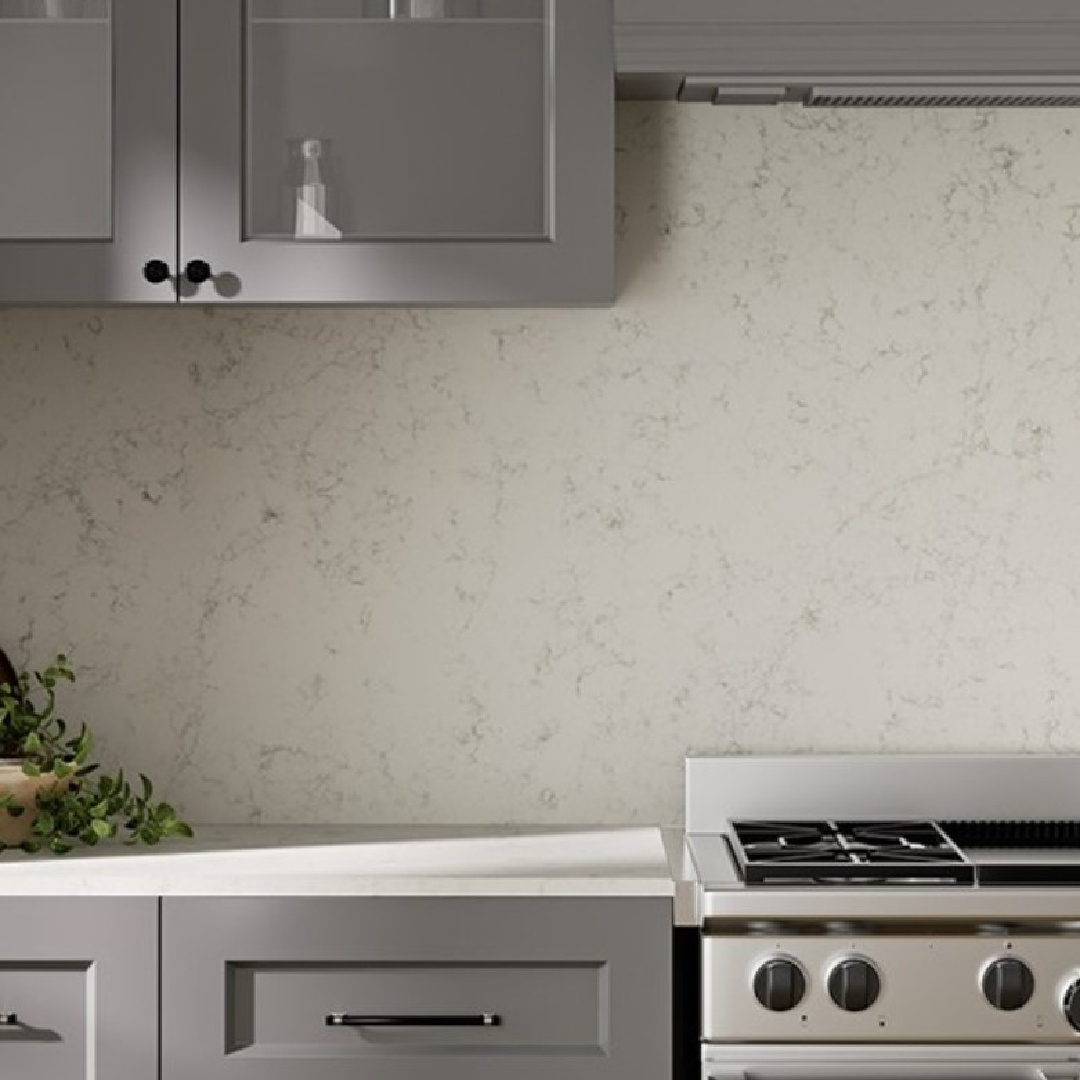 Cantata quartz (Viatera white countertops and backsplash) in a kitchen with gray cabinets. #cantataquartz