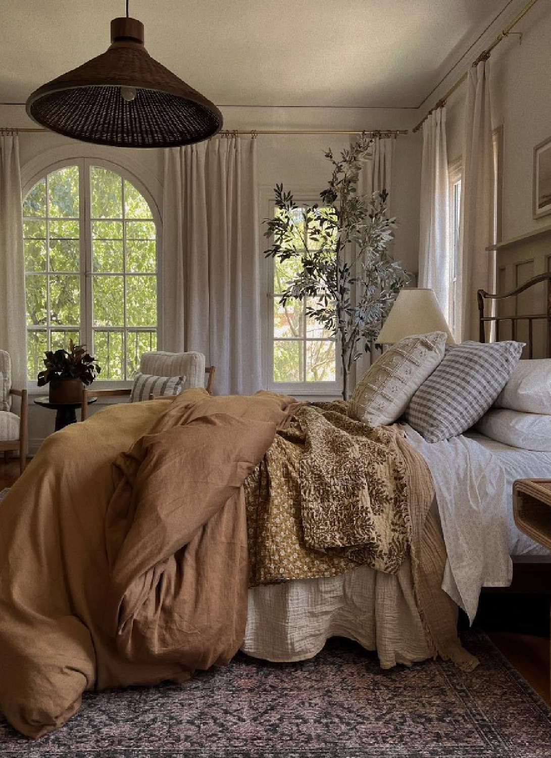 Amber Lewis designed cozy modern rustic romantic bedroom with warm colors, sumptuous bedding and rug, arched windows, and soothing California organic cool vibe. #cozybedrooms #cozyluxe #amberlewisbedroom