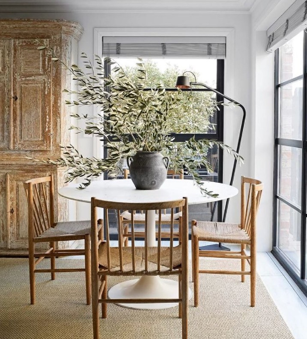 Beautiful, minimal modern English cottage dining room with Saarinen table and wood chairs from Anton & K. #modernenglishcountry #europeancountry