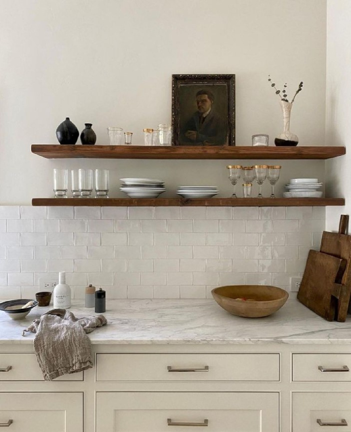 @cestesdesign - lovely white English country vibes in a kitchen with subway tile, marble, and warm wood rustic floating shelves. #englishcountry #whitekitchens #moderncountrykitchens