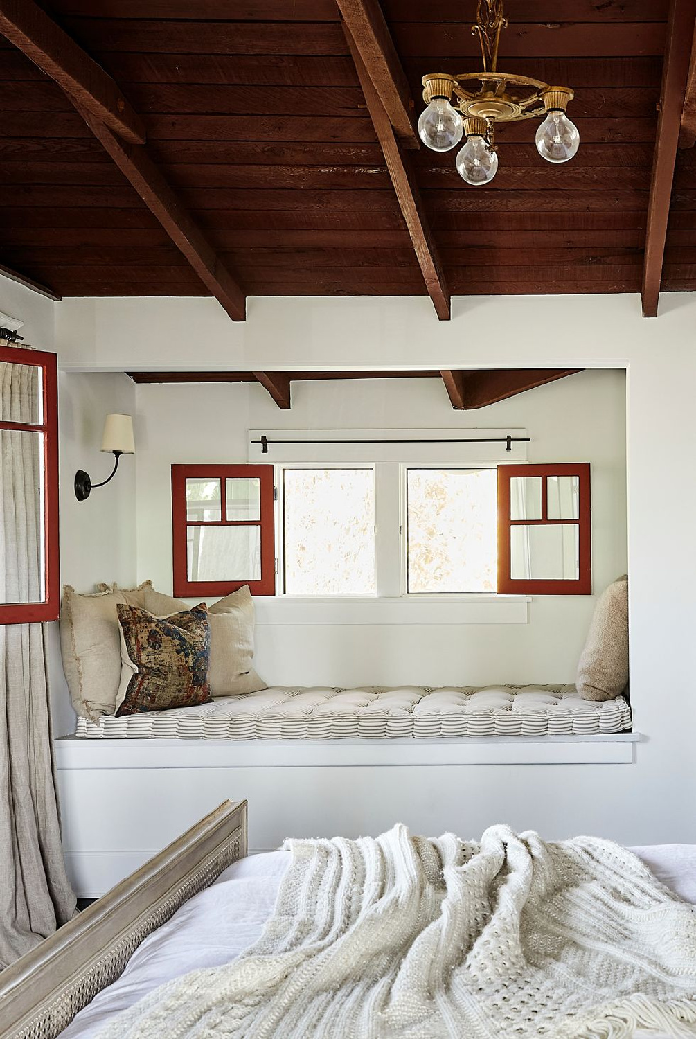 Benjamin Moore Chantilly Lace in a cozy bedroom with window seat and wood ceiling - Jamie Haller design. House Beautiful - Photo: Jenna Ohtemus Peffley. #chantillylace