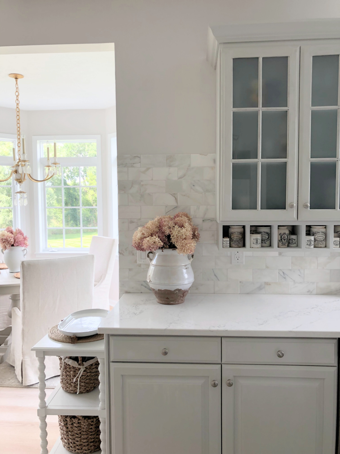 Serene white and light grey European country kitchen with Viatera Muse quartz counters, calacatta gold backsplash, and Pavilion Gray painted cabinets - Hello Lovely Studio. #eiderwhite #modernfrench #europeancountry #viateramuse