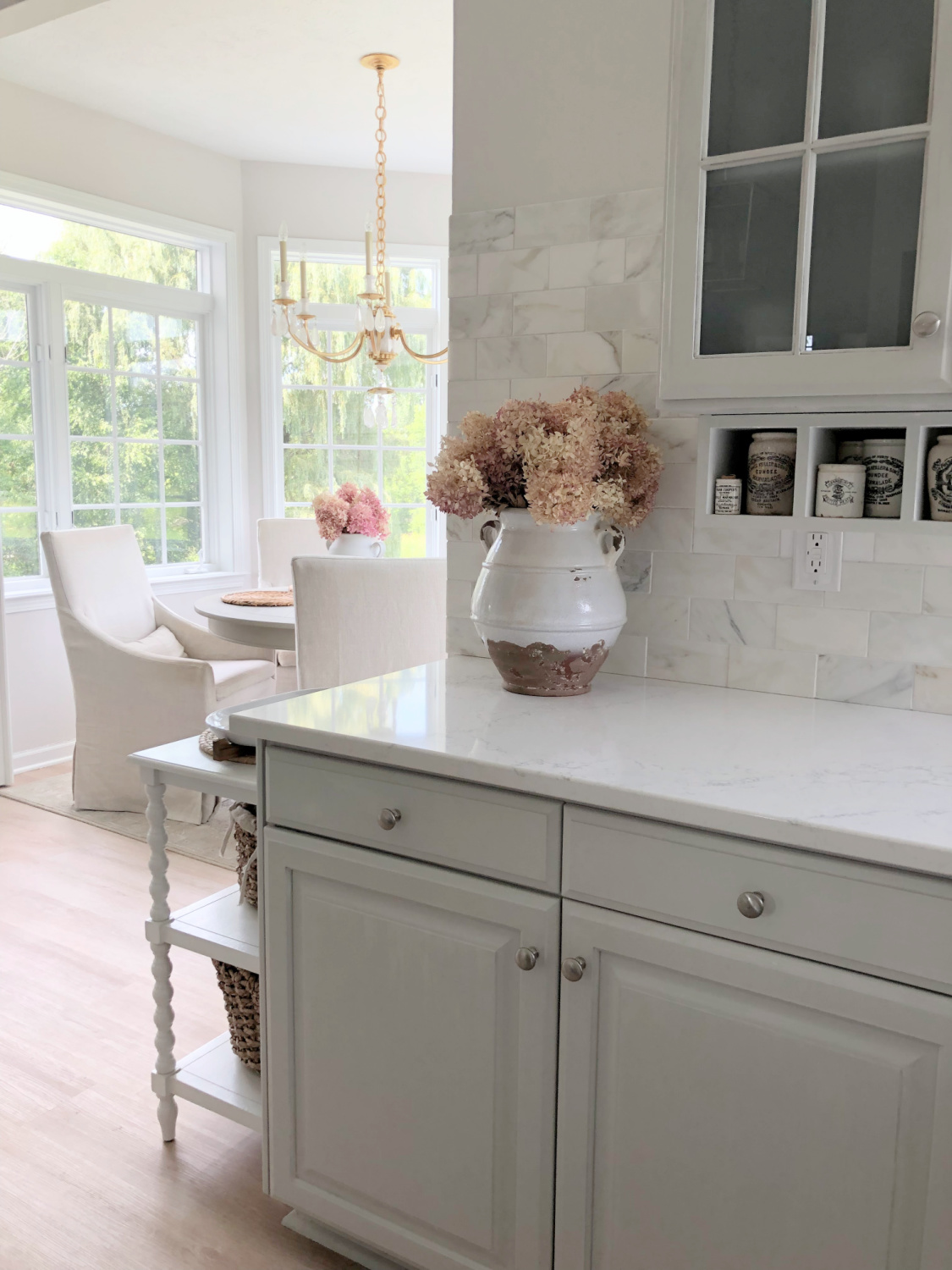 Serene white and light grey European country kitchen with Viatera Muse quartz counters, calacatta gold backsplash, and Pavilion Gray painted cabinets - Hello Lovely Studio. #eiderwhite #modernfrench #europeancountry #viateramuse