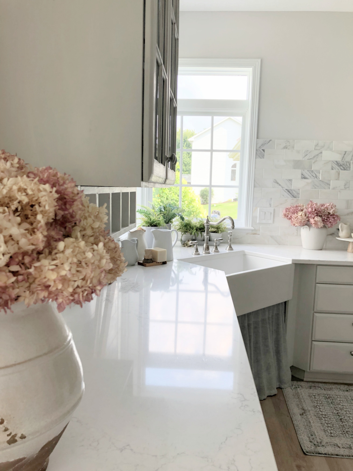 Serene white and light grey European country kitchen with Viatera Muse quartz counters, calacatta gold backsplash, and Pavilion Gray painted cabinets - Hello Lovely Studio. #eiderwhite #modernfrench #europeancountry #viateramuse