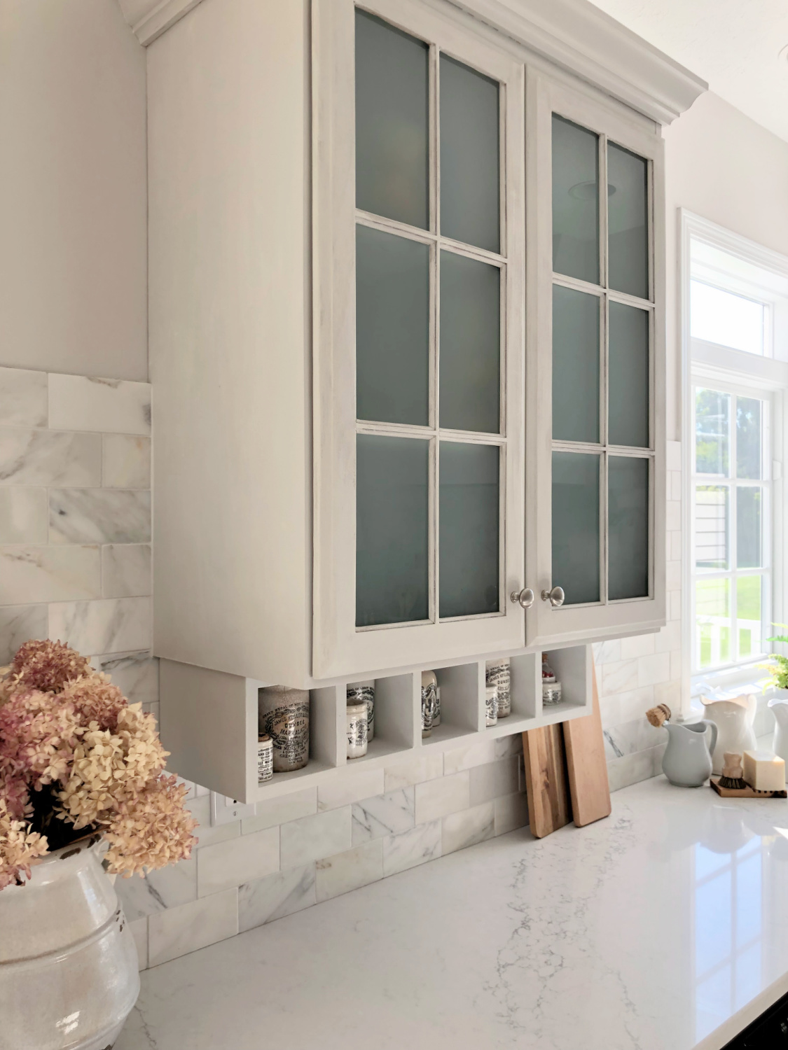 Serene white and light grey European country kitchen with Viatera Muse quartz counters, calacatta gold backsplash, and Pavilion Gray painted cabinets - Hello Lovely Studio. #eiderwhite #modernfrench #europeancountry #viateramuse