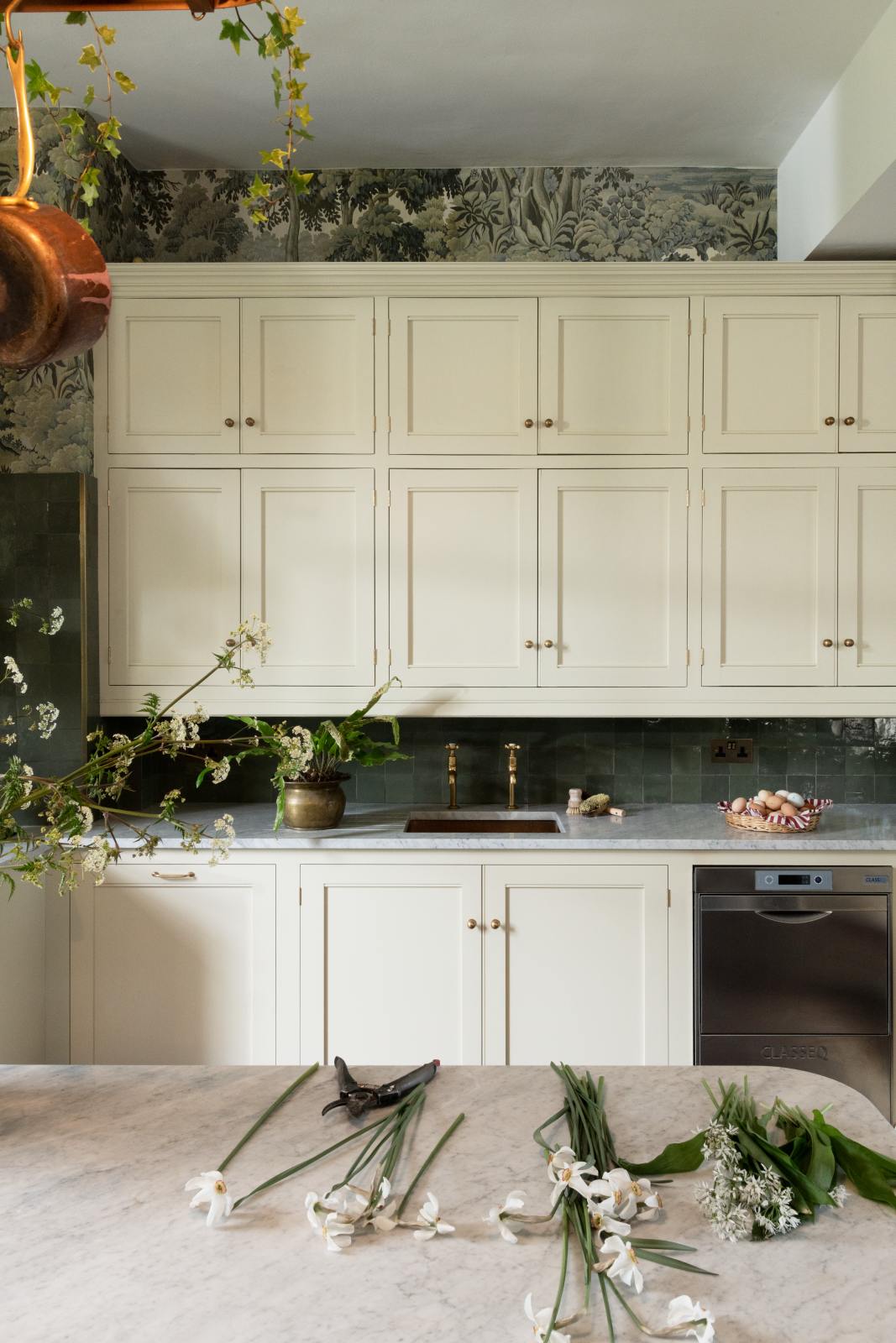 Pale green cabinets and deep moody green tile backsplash in the English country kitchen renovated with deVOL at Castle Trematon with House of Hackney wall covering and design. #devolkitchens #castletrematon