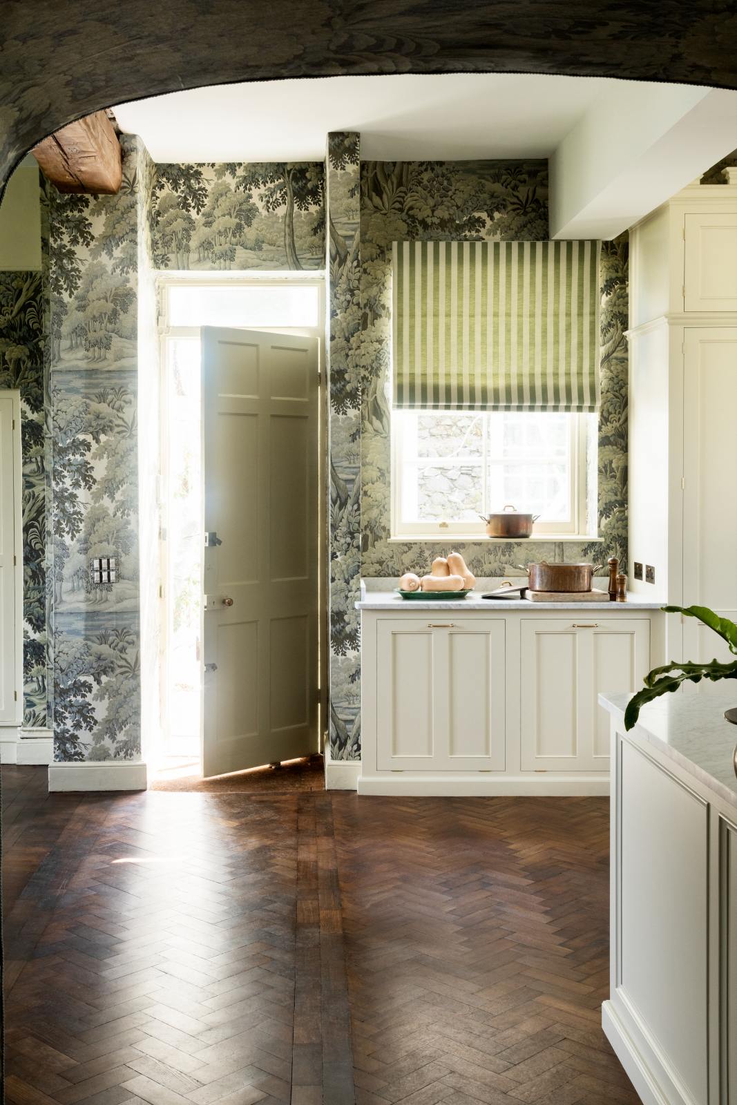 Pale green cabinets, copper hood over Italian range, marble topped Dairy Table, and Plantasia wallpaper in sage in the English country kitchen renovated with deVOL at Castle Trematon by House of Hackney. #devolkitchens #castletrematon