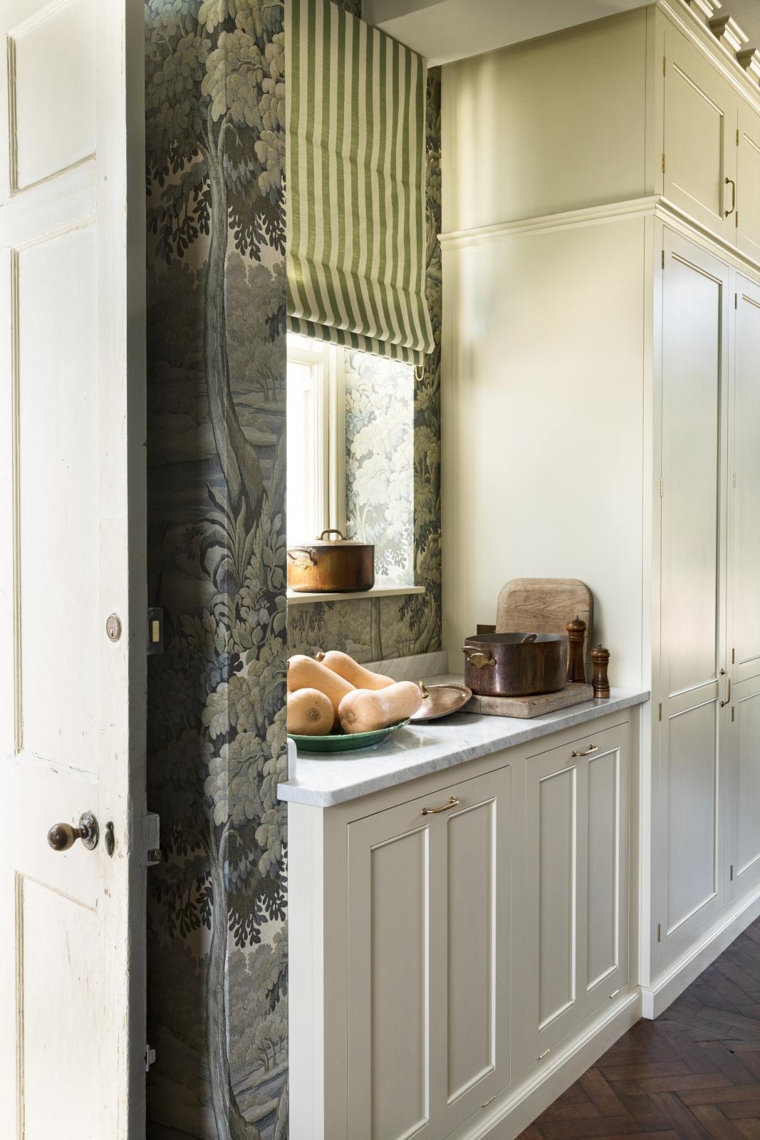 Pale green cabinets, copper hood over Italian range, marble topped Dairy Table, and Plantasia wallpaper in sage in the English country kitchen renovated with deVOL at Castle Trematon by House of Hackney. #devolkitchens #castletrematon
