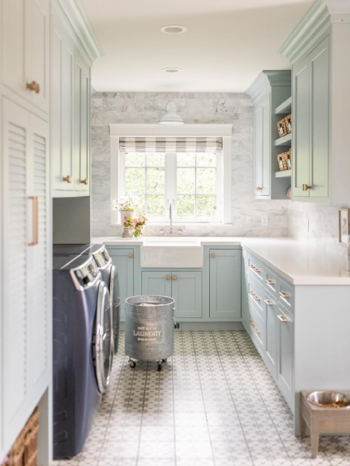 Benjamin Moore Smoke painted cabinetry in a beautiful laundry room designed by Jillian Harris. #bmsmoke #bluekitchencabinets