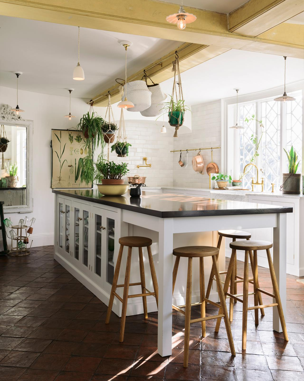deVOL English country kitchen with white cabinets, brass hardware, hanging plants, and Helen stool. #countrykitchendesign #devolkitchens