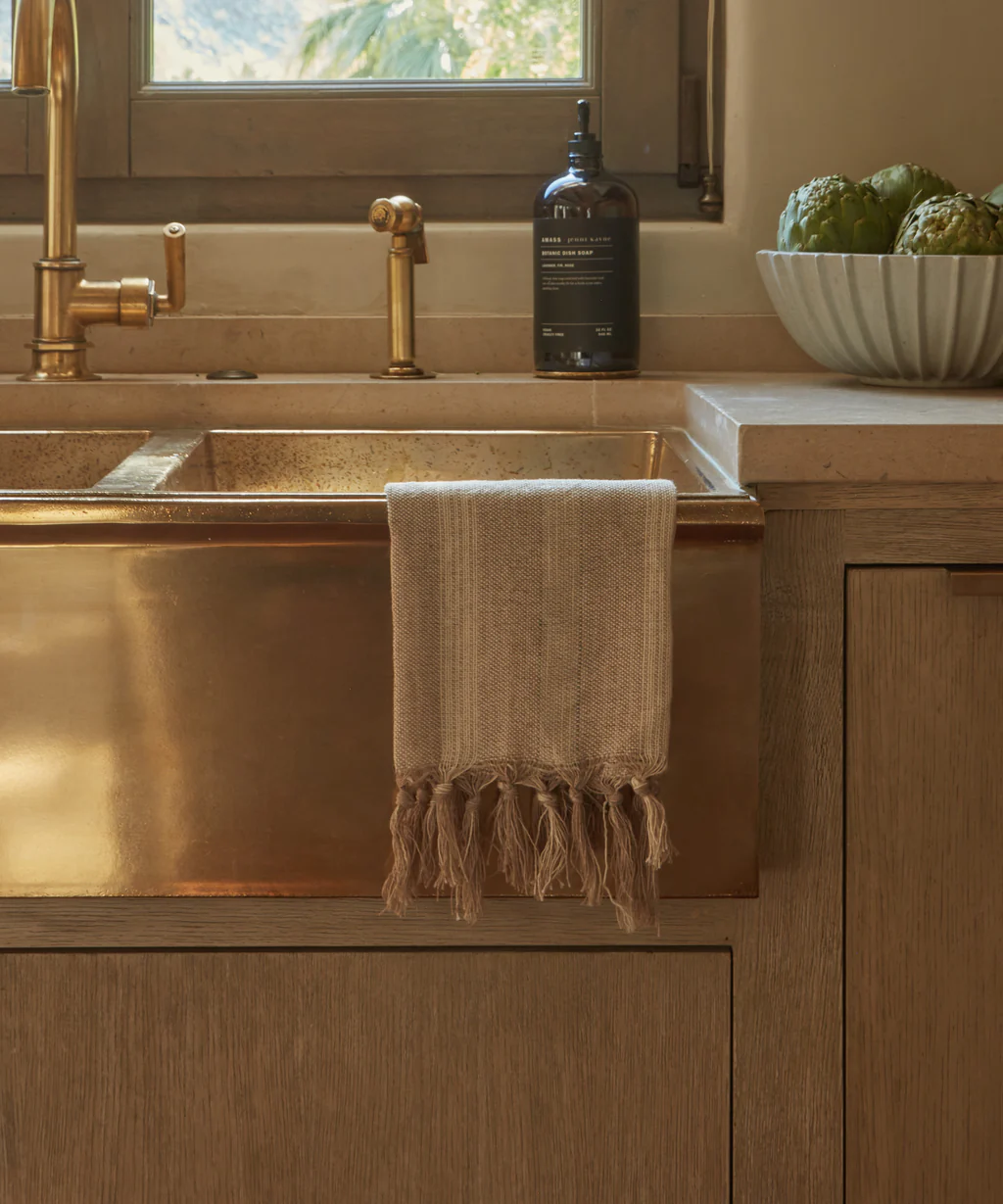 Laurel Hand Towel draped over apron front sink in beautiful warm kitchen with unlacquered brass faucet, Jenni Kayne Home. #linentowels #warmrusticmodern #californiacozy