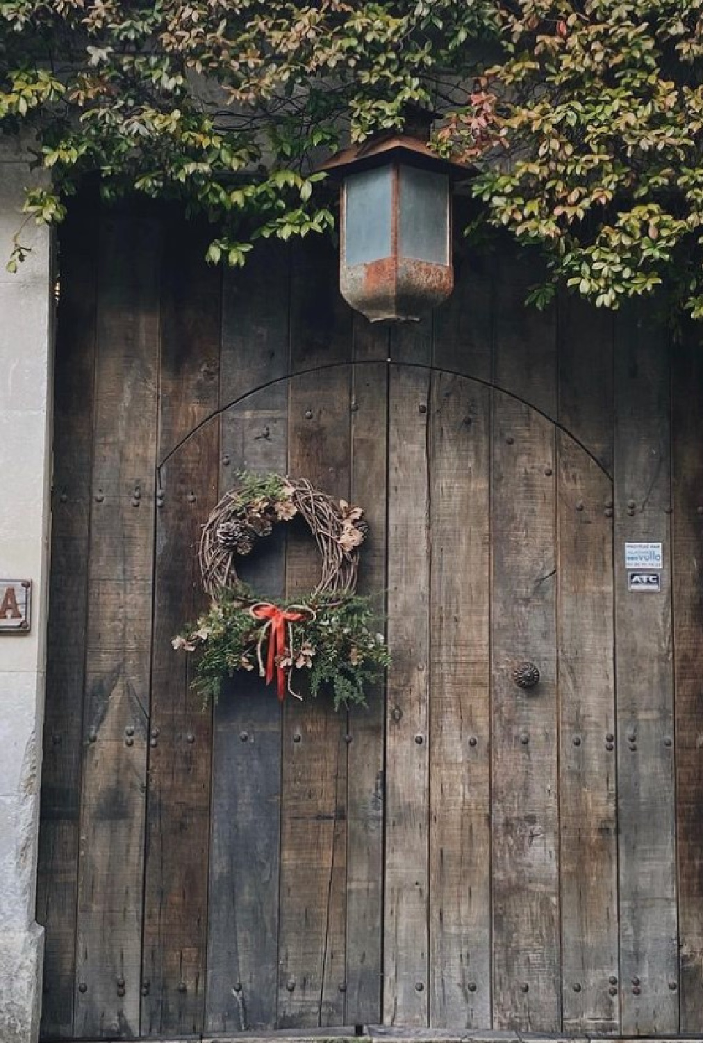 Lovely rustic Christmas wreath on a rugged wood door in Provence - @3_sources. #frenchchristmas #provencechristmas