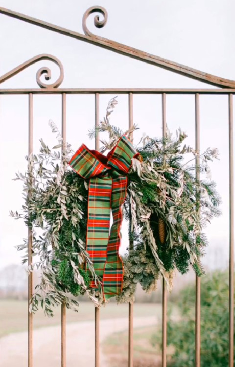 Natural Christmas wreath with stripe ribbon on a French gate in Provence - @provencepoiriers. #frenchchristmas