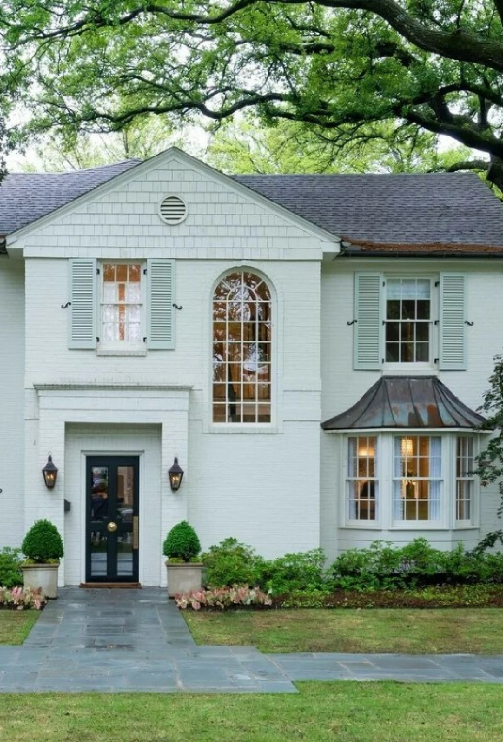 Mizzle (Farrow & Ball) painted shutters on a beautiful white house exterior - @1894home. #farrowandballmizzle