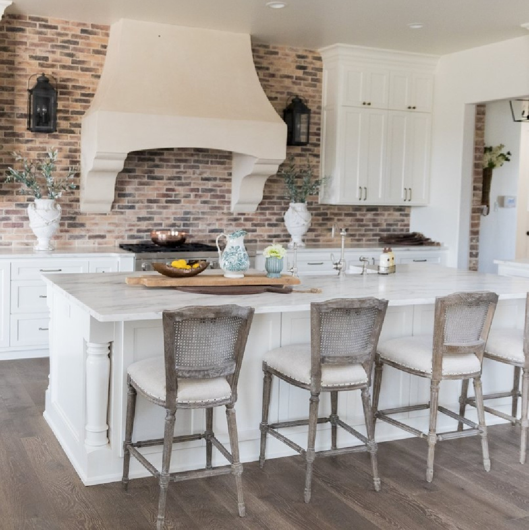 Sherwin-Williams Alabaster in a beautiful country French kitchen with Old World style and Chicago brick backsplash - design by Brit Jones. #swalabaster #modernfrench