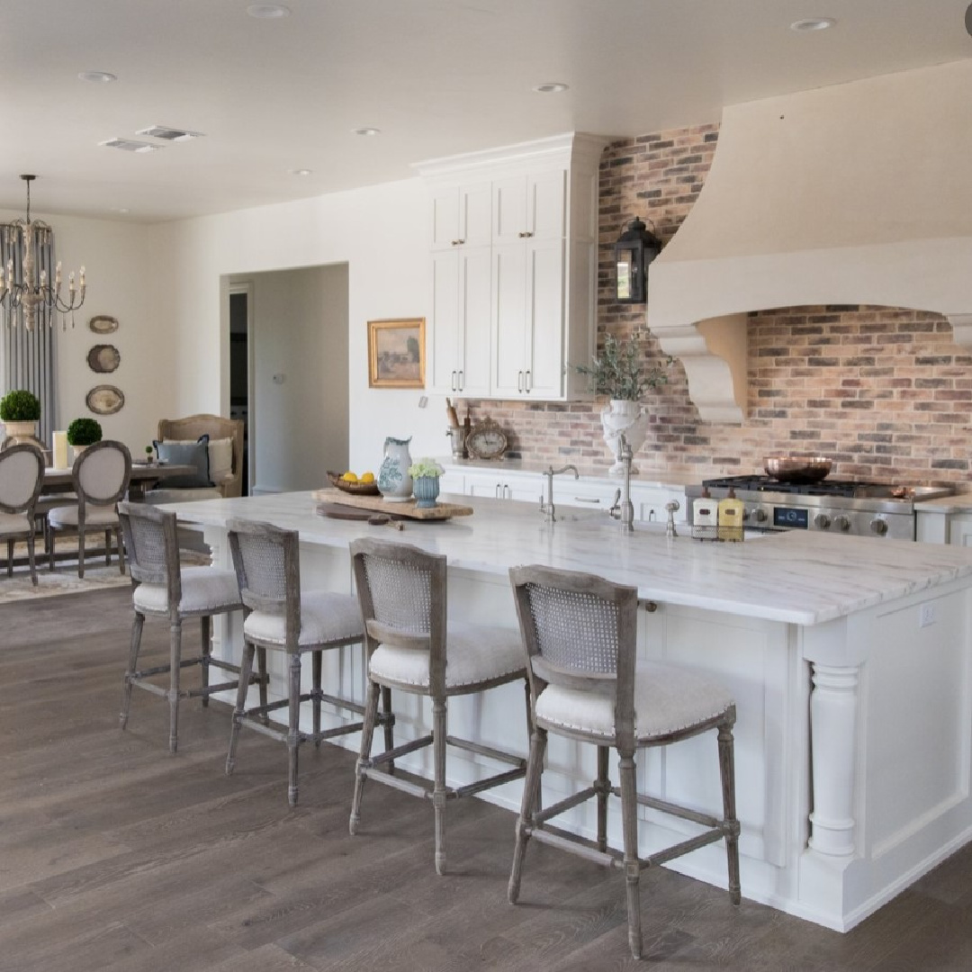 Sherwin-Williams Alabaster in a beautiful country French kitchen with Old World style and Chicago brick backsplash - design by Brit Jones. #swalabaster #modernfrench