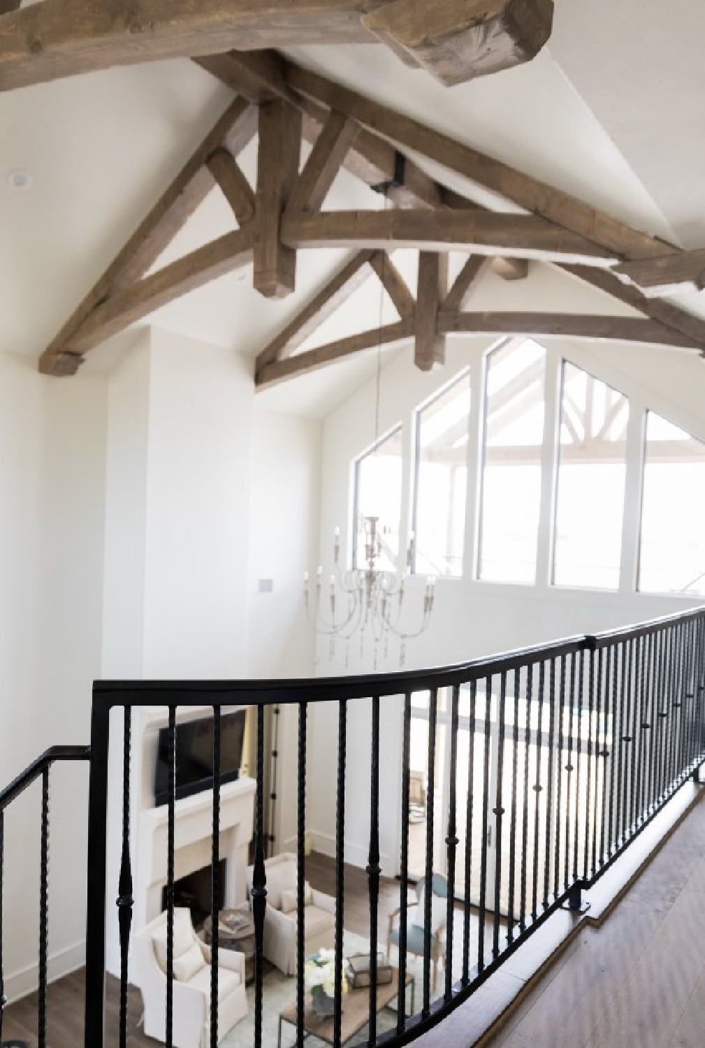 SW Alabaster on walls in a lofty Country French home with rustic wood trusses and elegant staircase - Brit Jones Design. #swalabaster