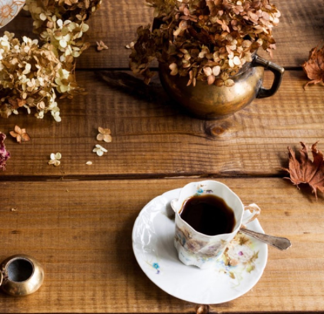 Cozy fall flatlay with copper, dried hydrangea, and beautiful cup and saucer - PineconesandAcorns. #fallcozy #autumnflatlay