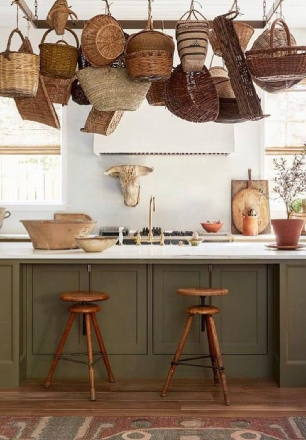 Olive green European country kitchen with antique baskets above island - Shannon Bowers Design (Photo: Laura Resen). #europeancountry #Frenchfarmhousekitchen #greenkitchens