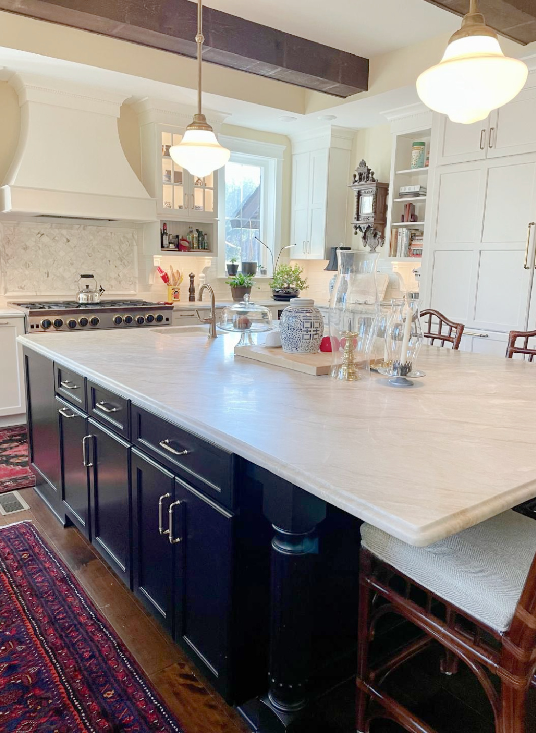 Hello Lovely - traditional kitchen with black island, white custom cabinets, Taj Mahal quartzite, farm sink, Bluestar range, and Chippendale stools. #traditionalkitchens #twotonekitchen