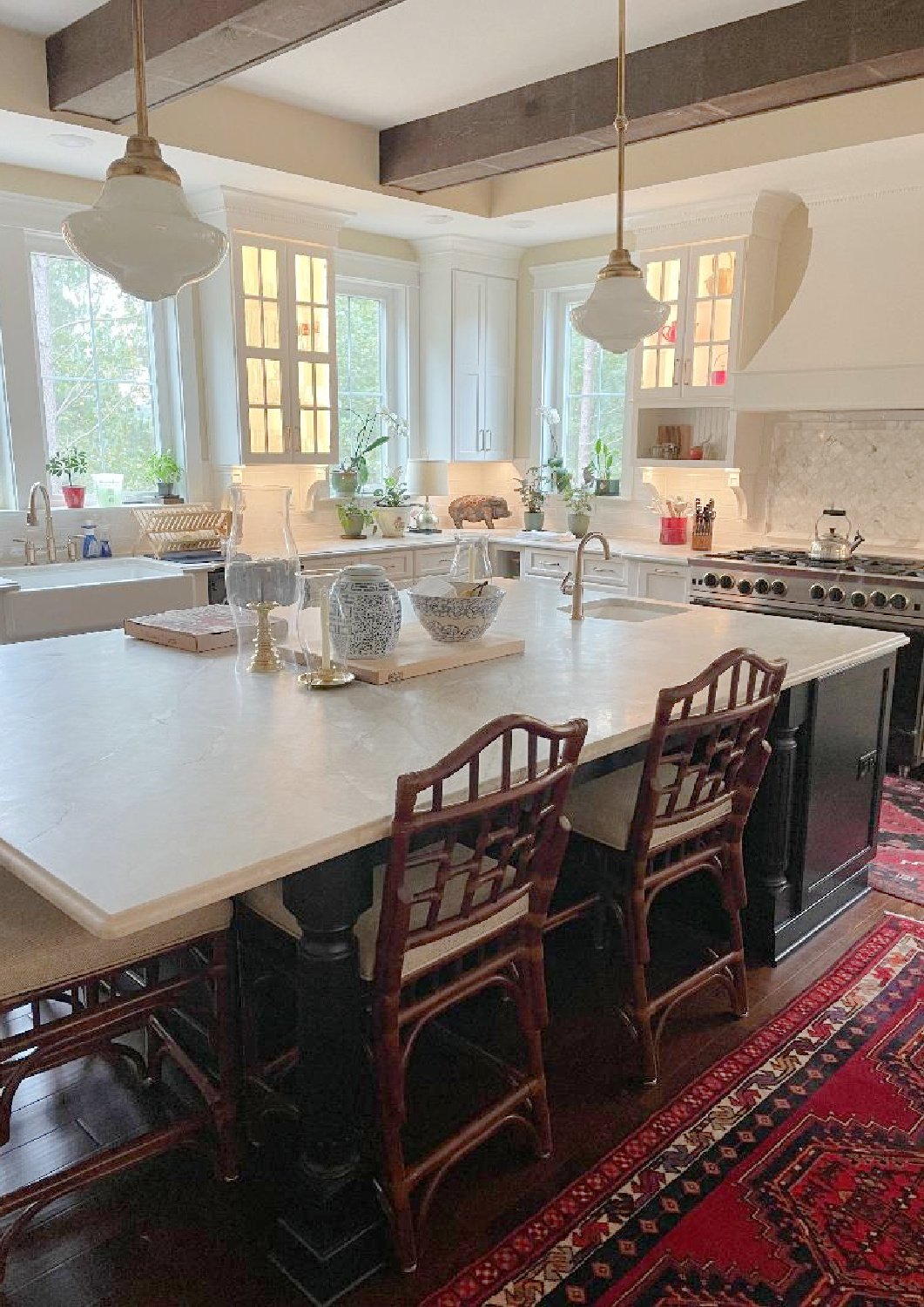 Hello Lovely - traditional kitchen with black island, white custom cabinets, Taj Mahal quartzite, farm sink, Bluestar range, and Chippendale stools. #traditionalkitchens #twotonekitchen