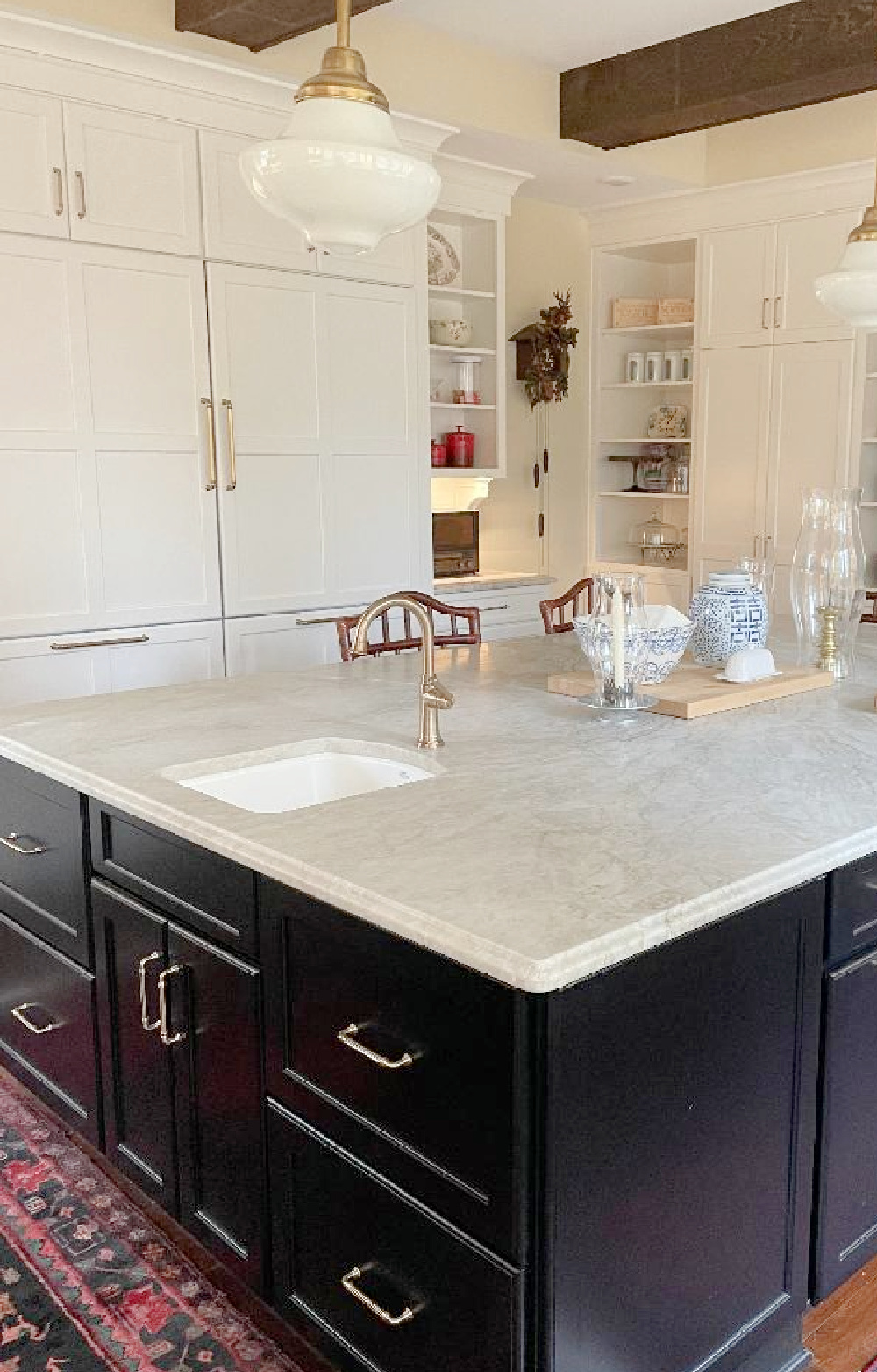 Hello Lovely - traditional kitchen with black island, white custom cabinets, Taj Mahal quartzite, farm sink, Bluestar range, and Chippendale stools. #traditionalkitchens #twotonekitchen