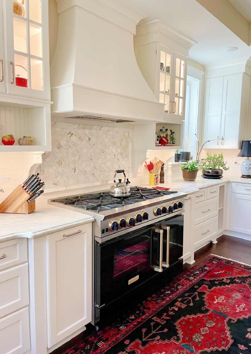 Hello Lovely - traditional kitchen with black island, white custom cabinets, Taj Mahal quartzite, farm sink, Bluestar range, and Chippendale stools. #traditionalkitchens #twotonekitchen