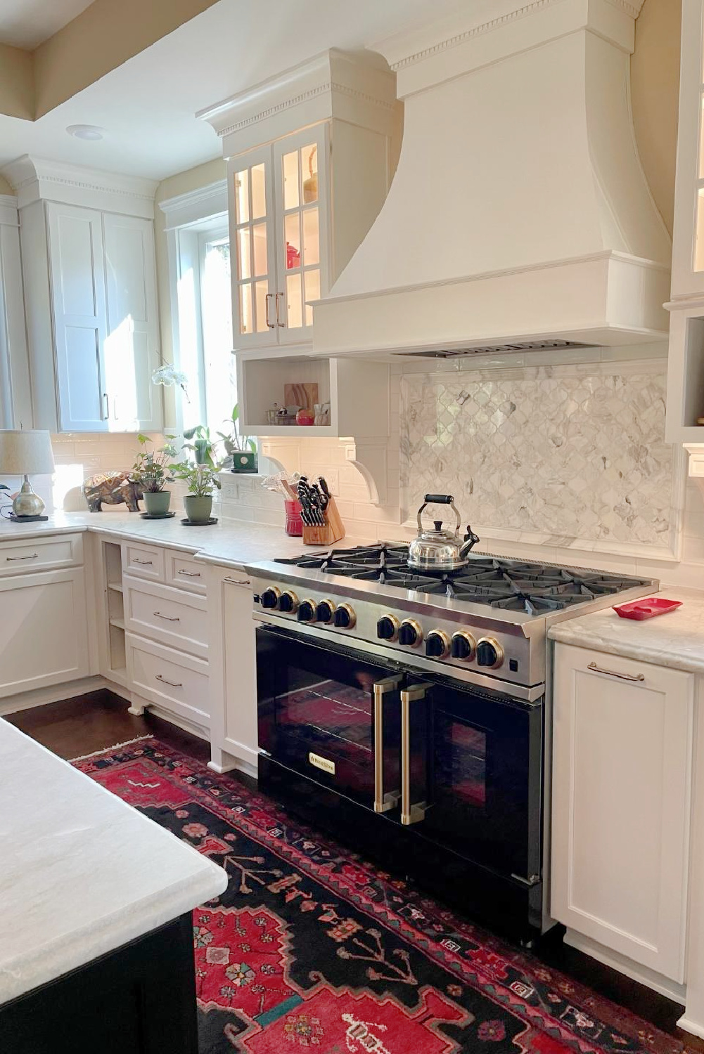 Hello Lovely - traditional kitchen with black island, white custom cabinets, Taj Mahal quartzite, farm sink, Bluestar range, and Chippendale stools. #traditionalkitchens #twotonekitchen