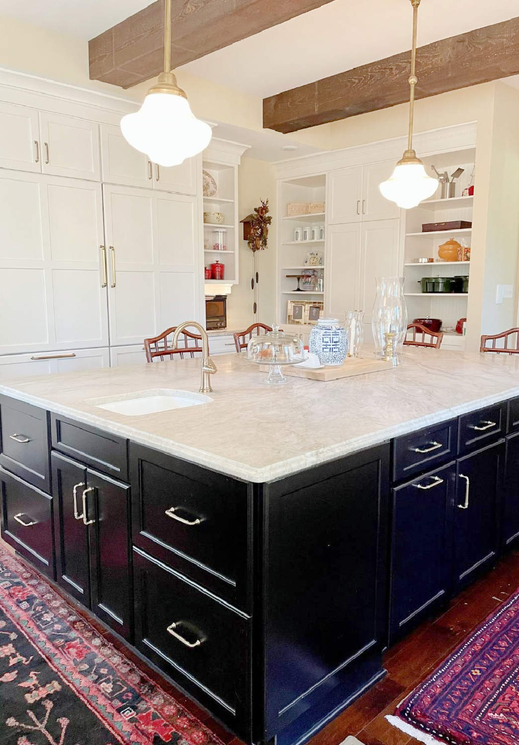 Hello Lovely - traditional kitchen with black island, white custom cabinets, Taj Mahal quartzite, farm sink, Bluestar range, and Chippendale stools. #traditionalkitchens #twotonekitchen