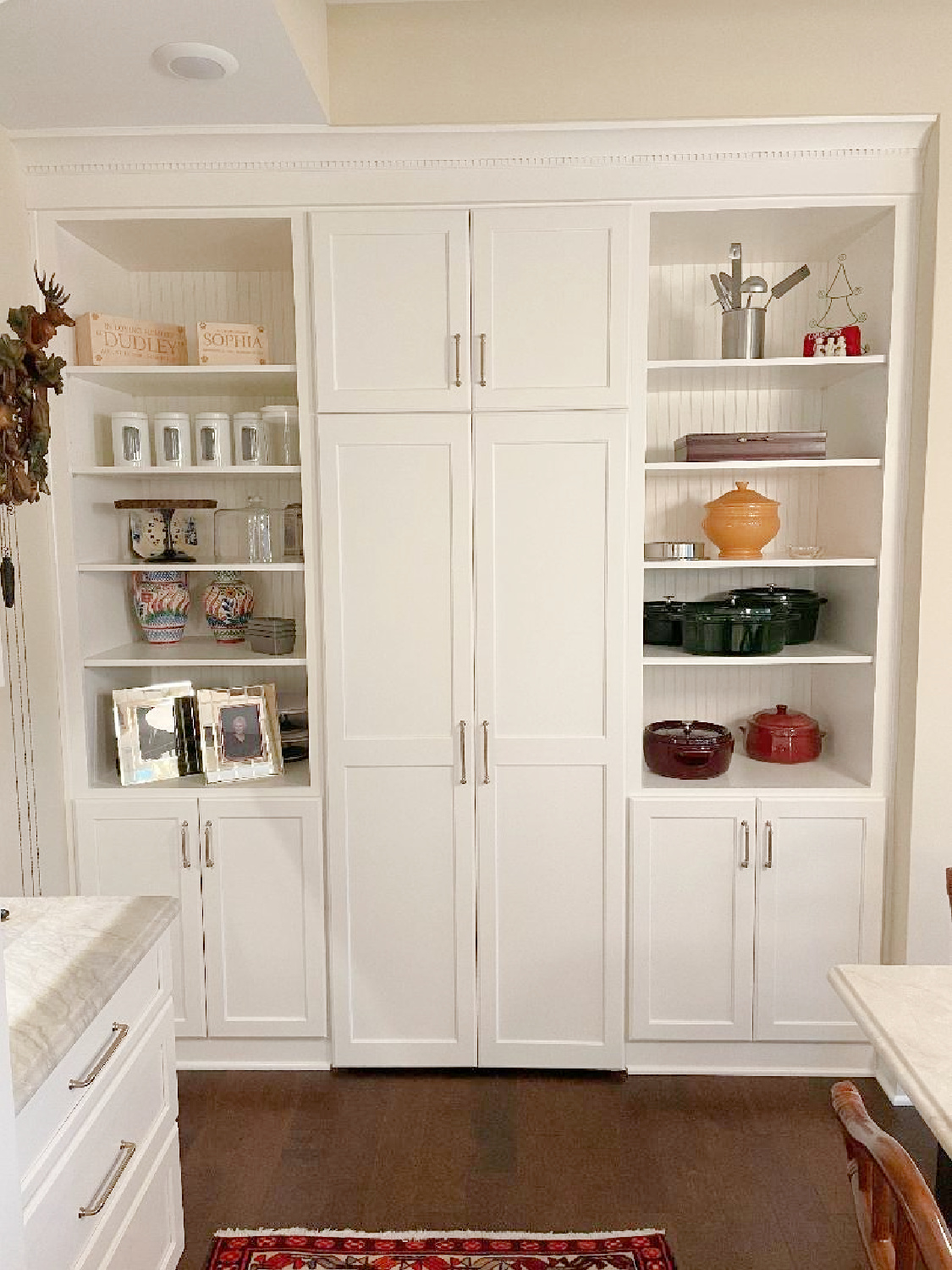 A beautiful timeless French kitchen with hidden pantry behind the tall cabinet doors - Hello Lovely Studio. #kitchenpantry #hiddenpantry