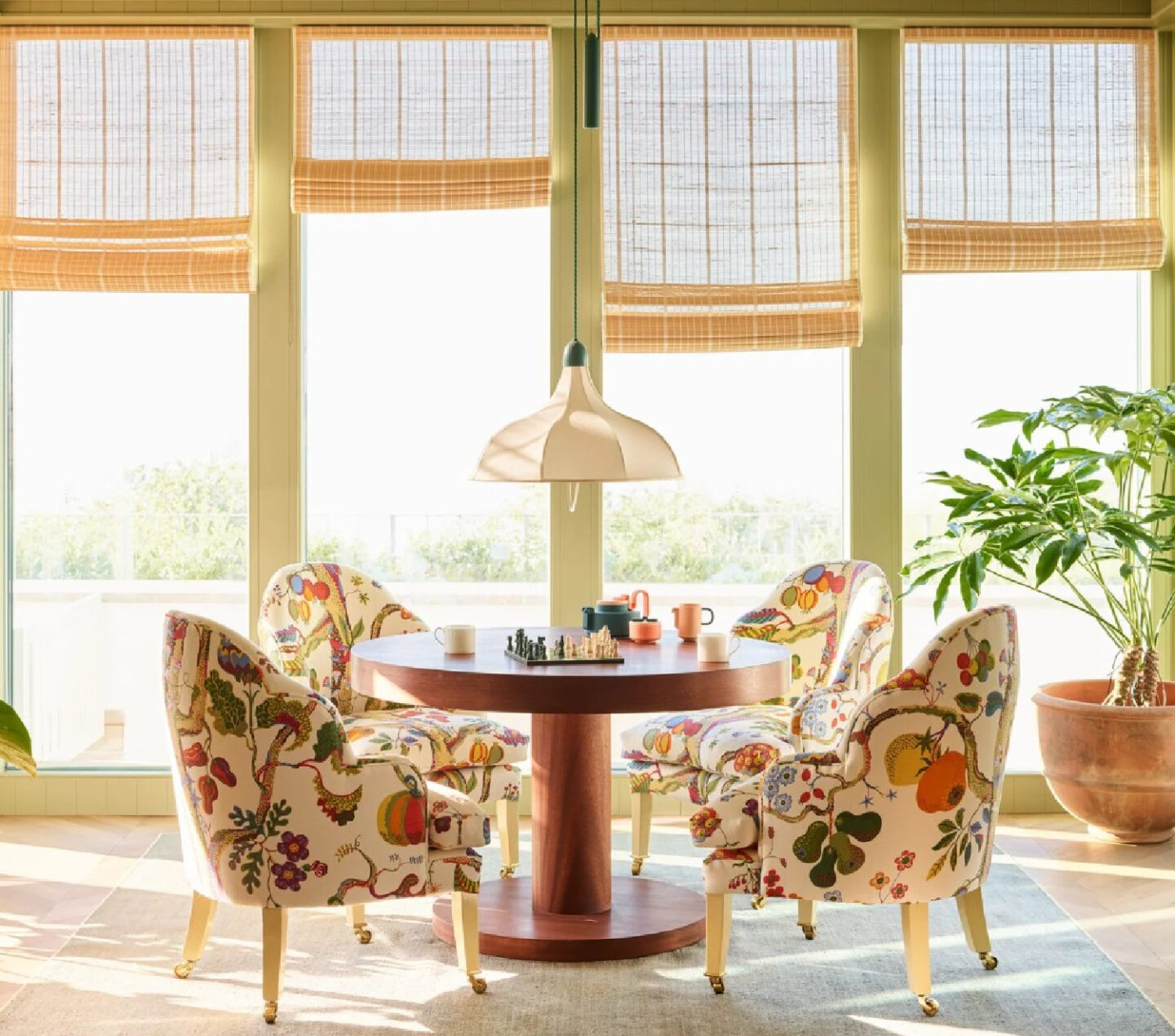 Gorgeous sun room with cheery floral chairs, green paneled walls and woven shades - Beata Heuman design, Robert Rieger photo.