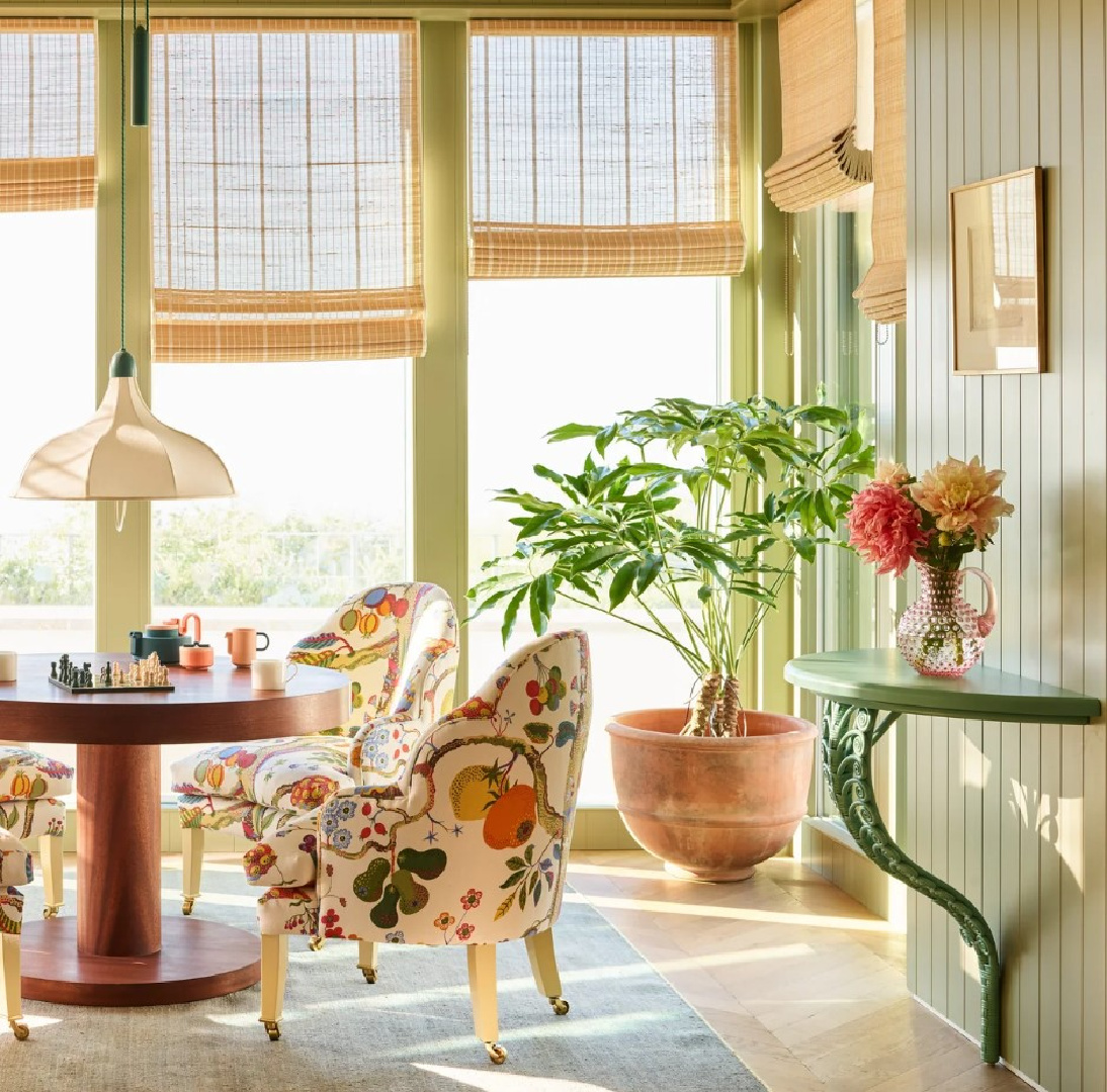 Gorgeous sun room with floral chairs, green paneled walls and woven shades - Beata Heuman design, Robert Rieger photo.