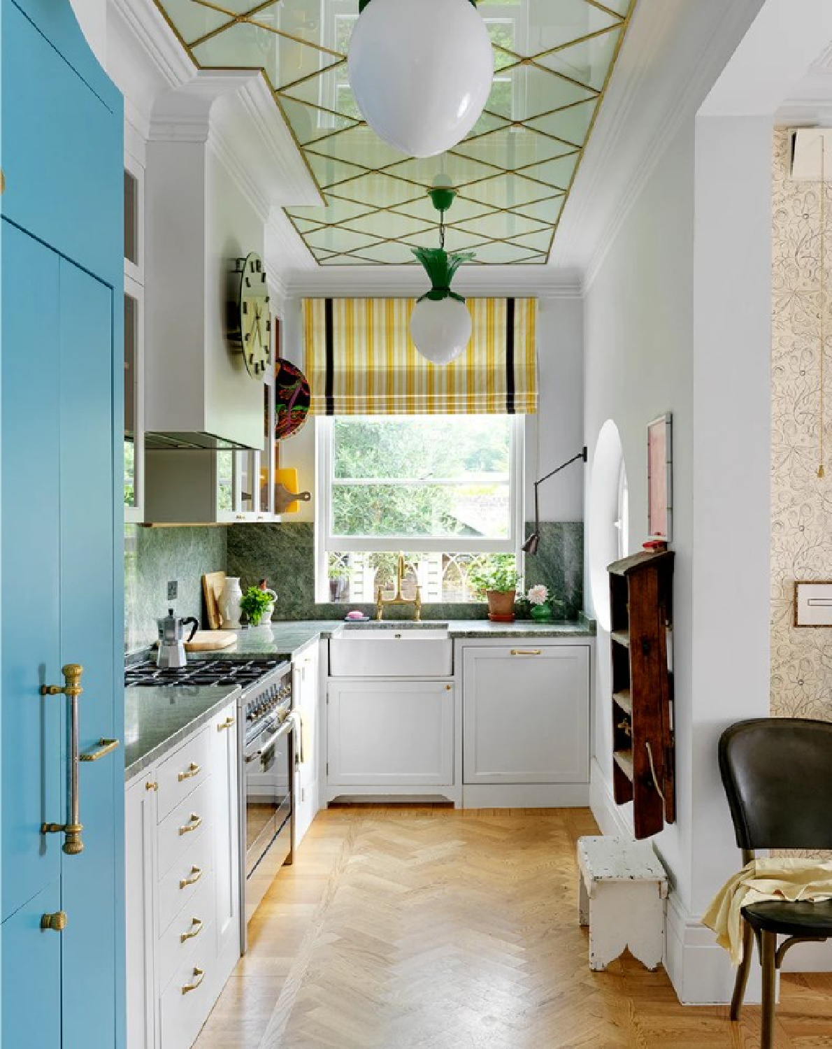 Beata Heuman designed kitchen in her UK riverside home with unique reflective ceiling detail and cheery blue paneled frig. Photo: Simon Brown.