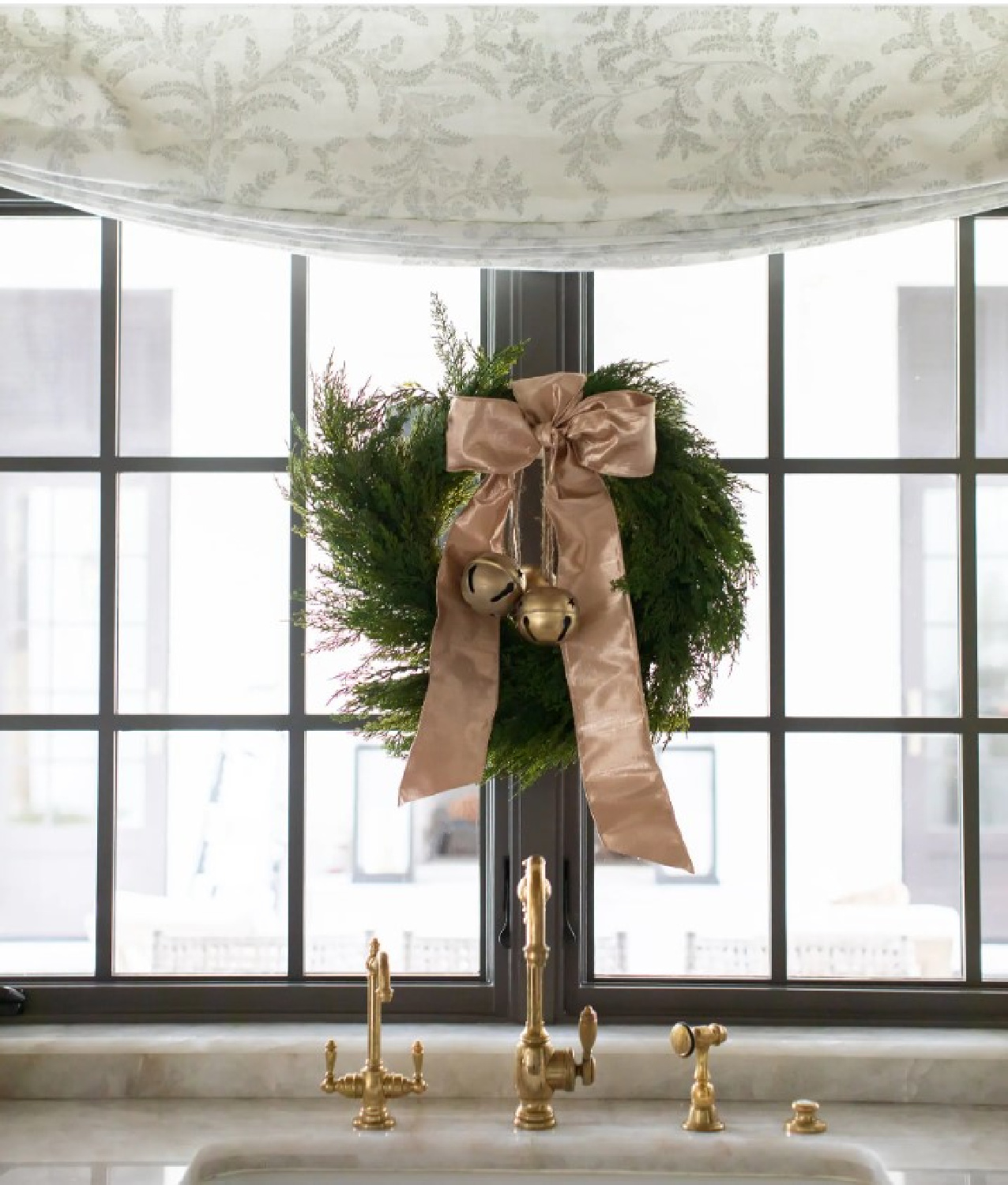 Lovely elegant Christmas wreath with blush pink ribbon at kitchen sink window - Marie Flanigan Interiors. #christmaswreaths #frenchcountrychristmas