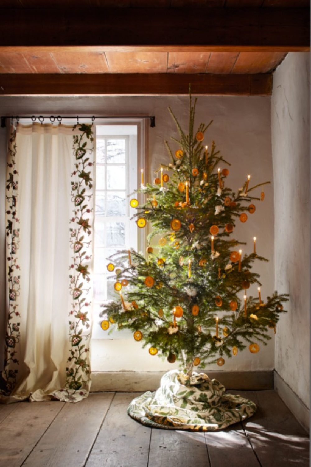 Beautiful Scandi Christmas tree with citrus dried orange slices and lit candles - designed by Michael Putnam in Veranda, photo by Sang An. #citruschristmas #scandichristmas #citrusgarland
