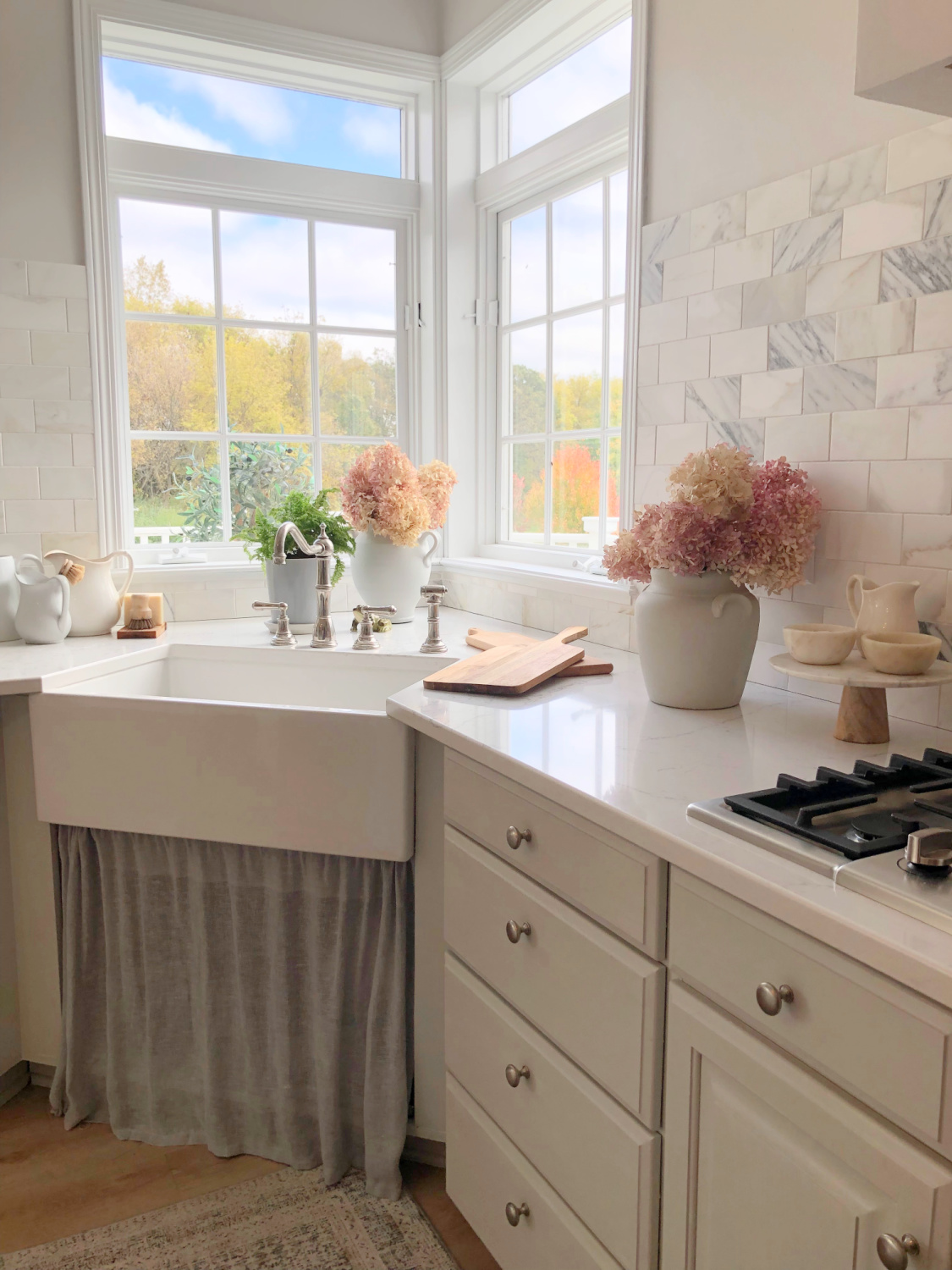 Modern French kitchen with Viatera Muse counters, SW Eider White, and light gray cabinets - Hello Lovely Studio.