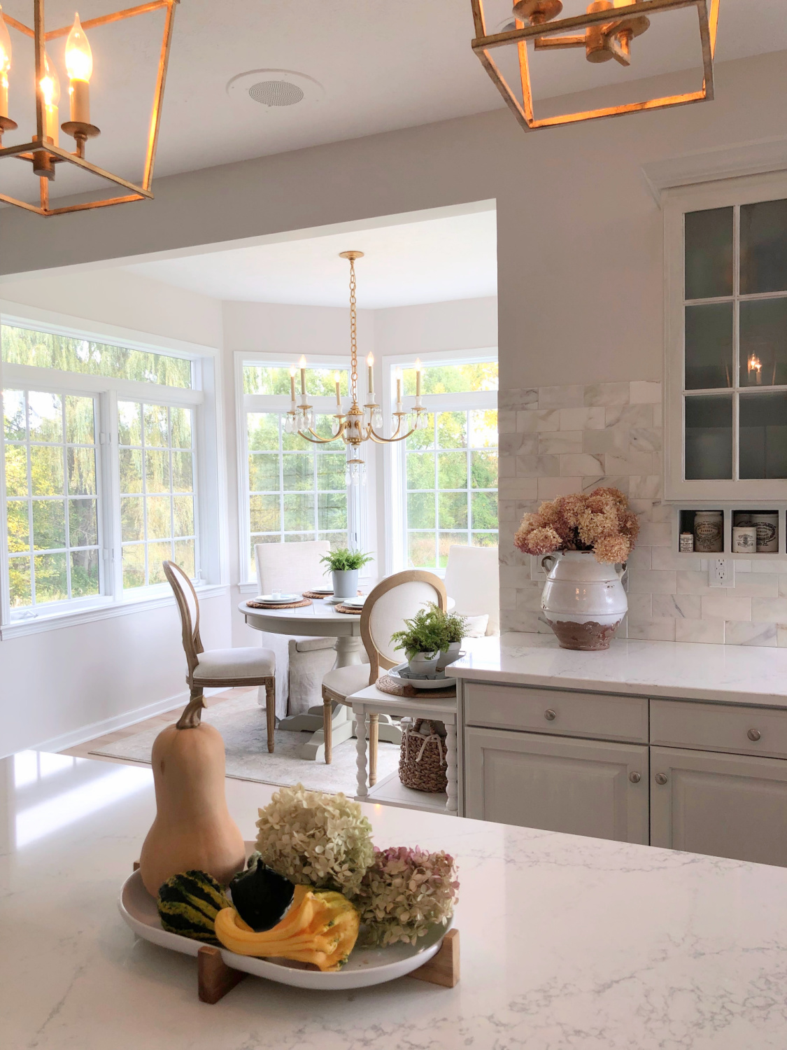 Modern French kitchen with Viatera Muse counters, SW Eider White, and light gray cabinets - Hello Lovely Studio.
