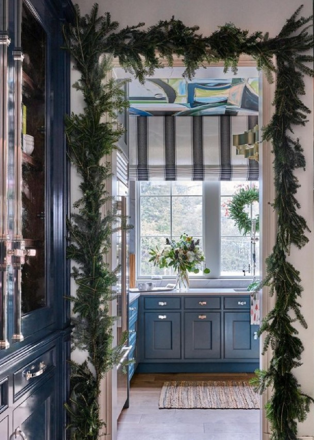 Holiday decorations and garland in a pantry with design by @blessedlittlebungalow for Atlanta Holiday House 2022. #holidaykitchen #elegantholidaydecor