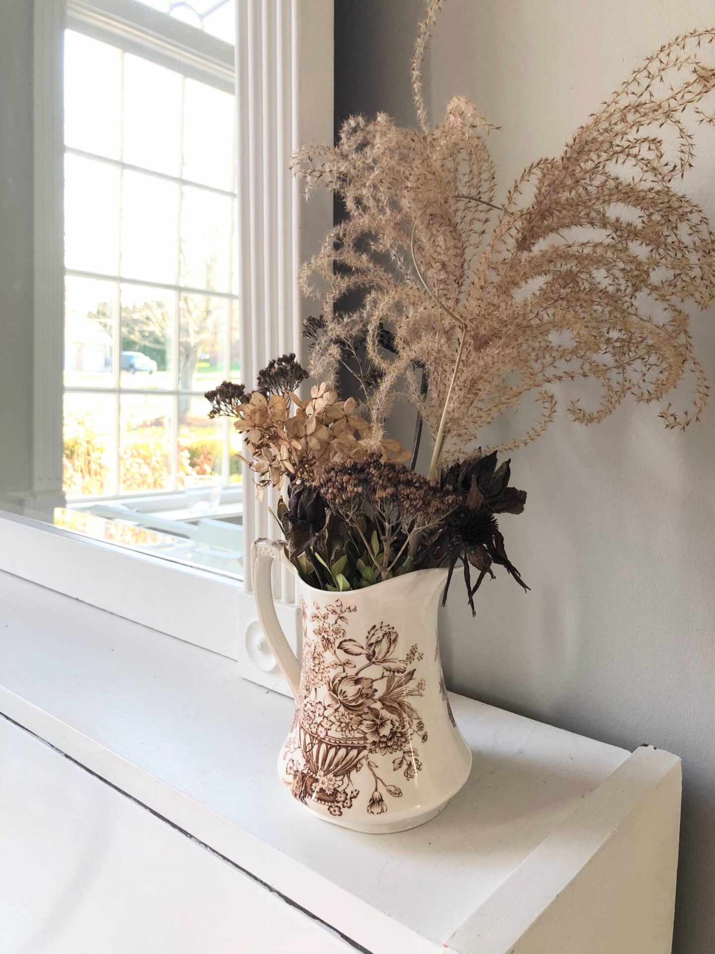 Fall foraged arrangement in brown transferware pitcher on white piano in my music room at the Georgian - Hello Lovely Studio. Paint color is SW Repose Gray.