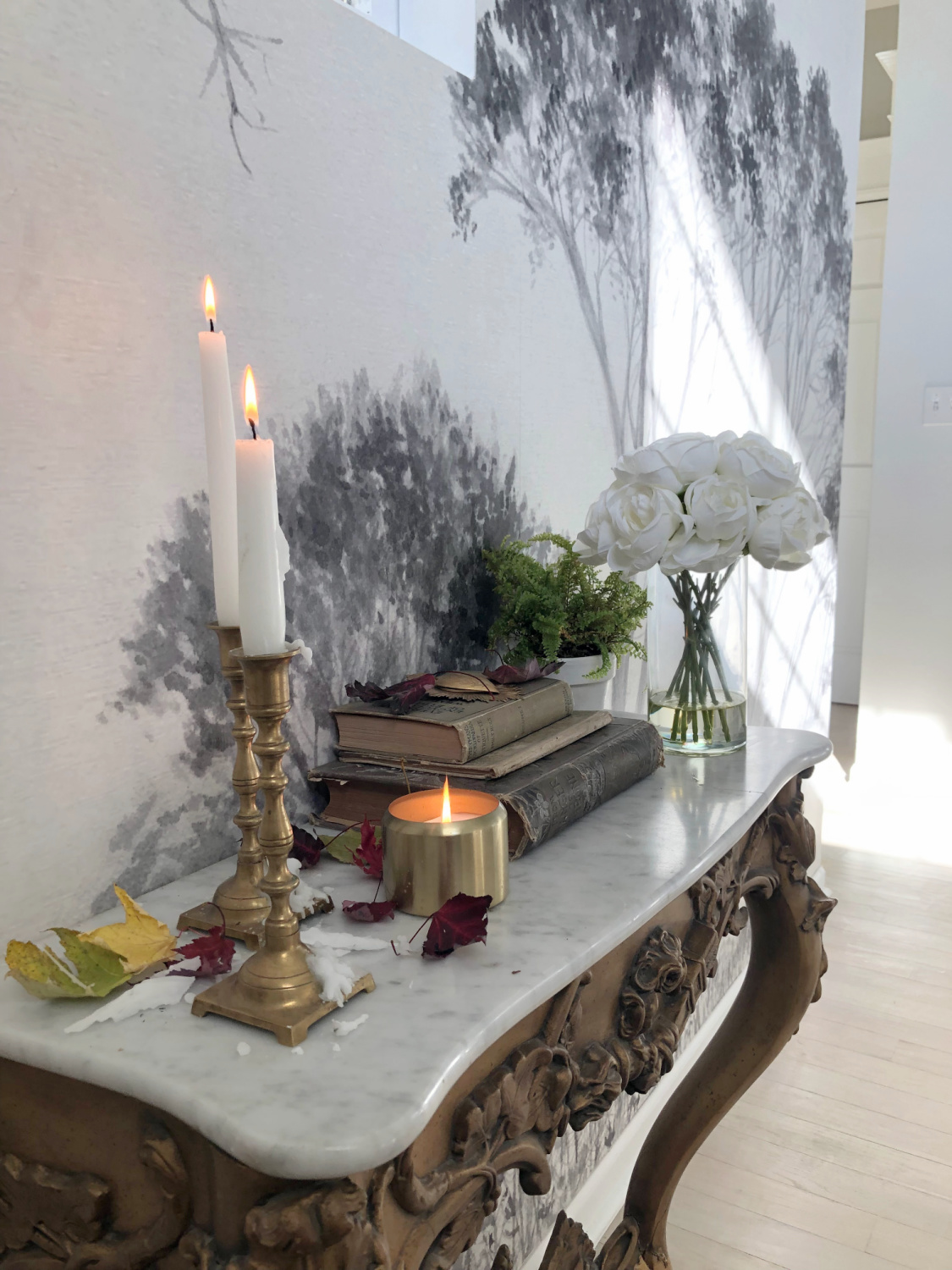 Hello Lovely's entry wallpaper mural with trees (Photowall) and French console with fall decor. #modernfrench #frenchconsole #treemural #grisaillemural