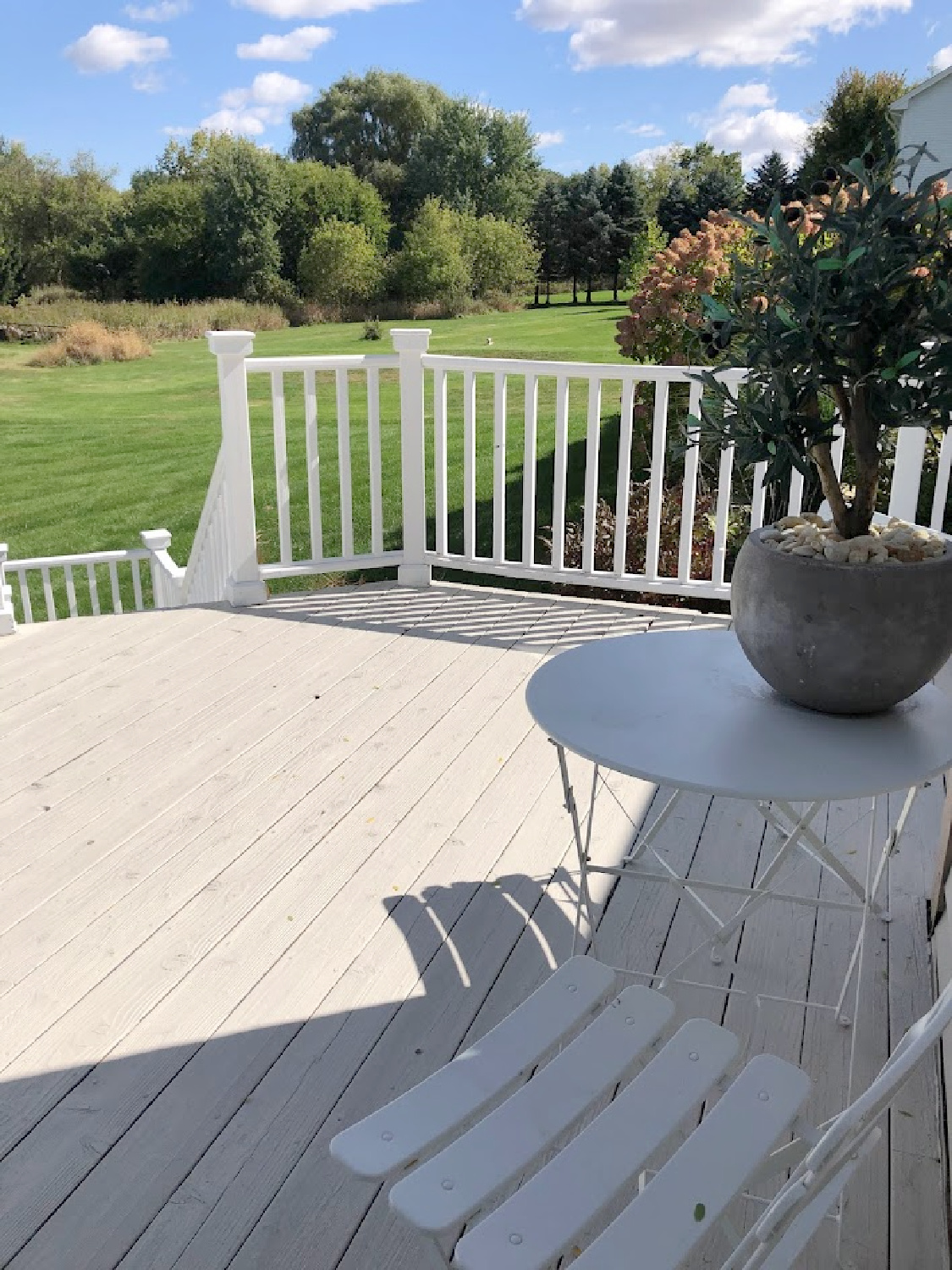 Hello Lovely's deck with white railing and gray flooring.